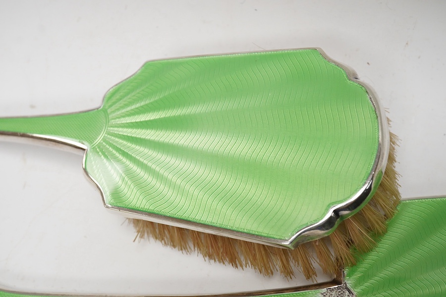 A George VI three piece silver and enamelled mirror and brush set by Adie Brothers, Birmingham, 1948 and a silver mounted comb. Condition - poor